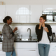 Two women chatting in the office kitchen